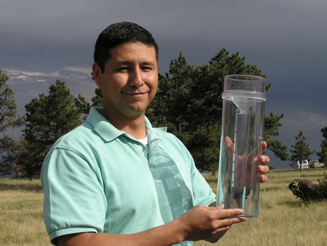 CoCoRaHS volunteer holding a rain gauge